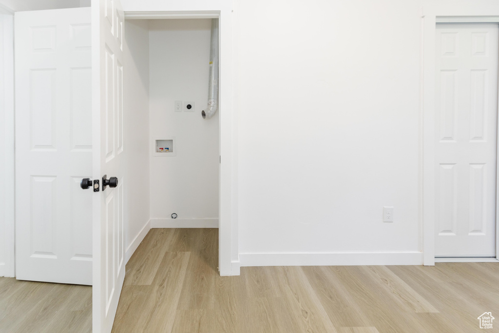 Washroom with light wood finished floors, hookup for an electric dryer, and hookup for a washing machine