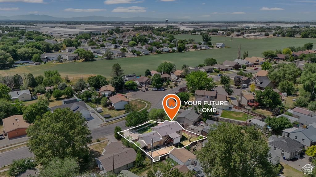Aerial perspective of suburban area featuring property boundaries highlighted and a mountainous background