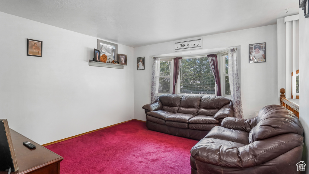 Carpeted living area featuring baseboards