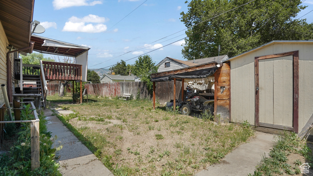 View of yard with a storage shed, a wooden deck, and stairway