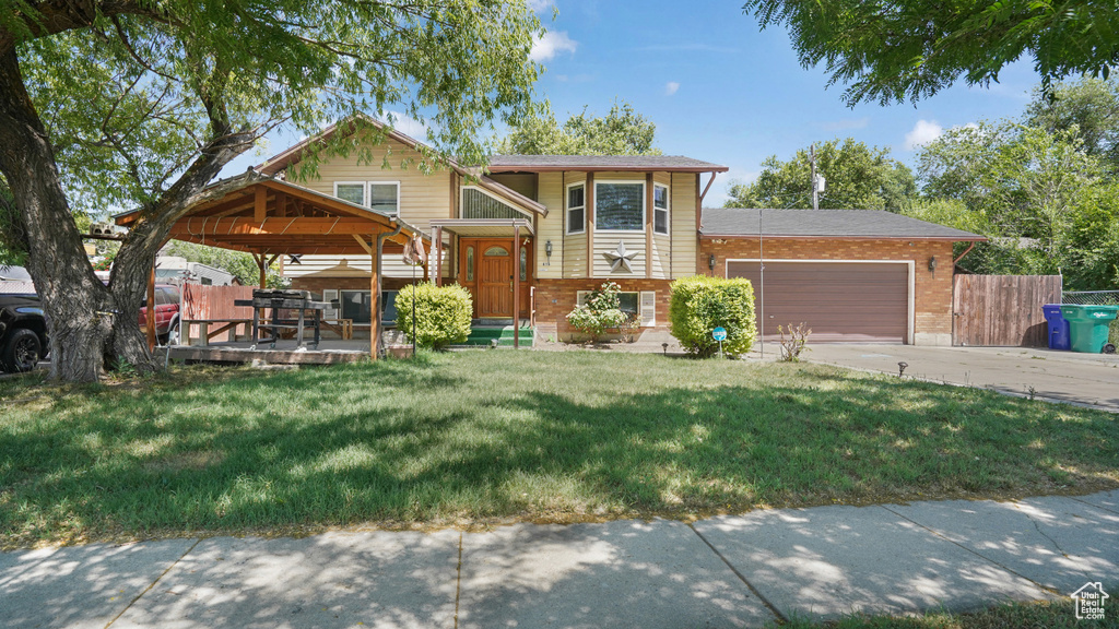 View of front of house with a garage, brick siding, a gazebo, and concrete driveway