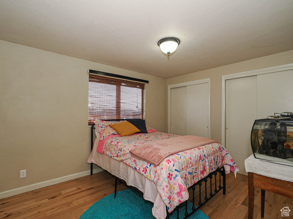 Bedroom featuring two closets and wood finished floors