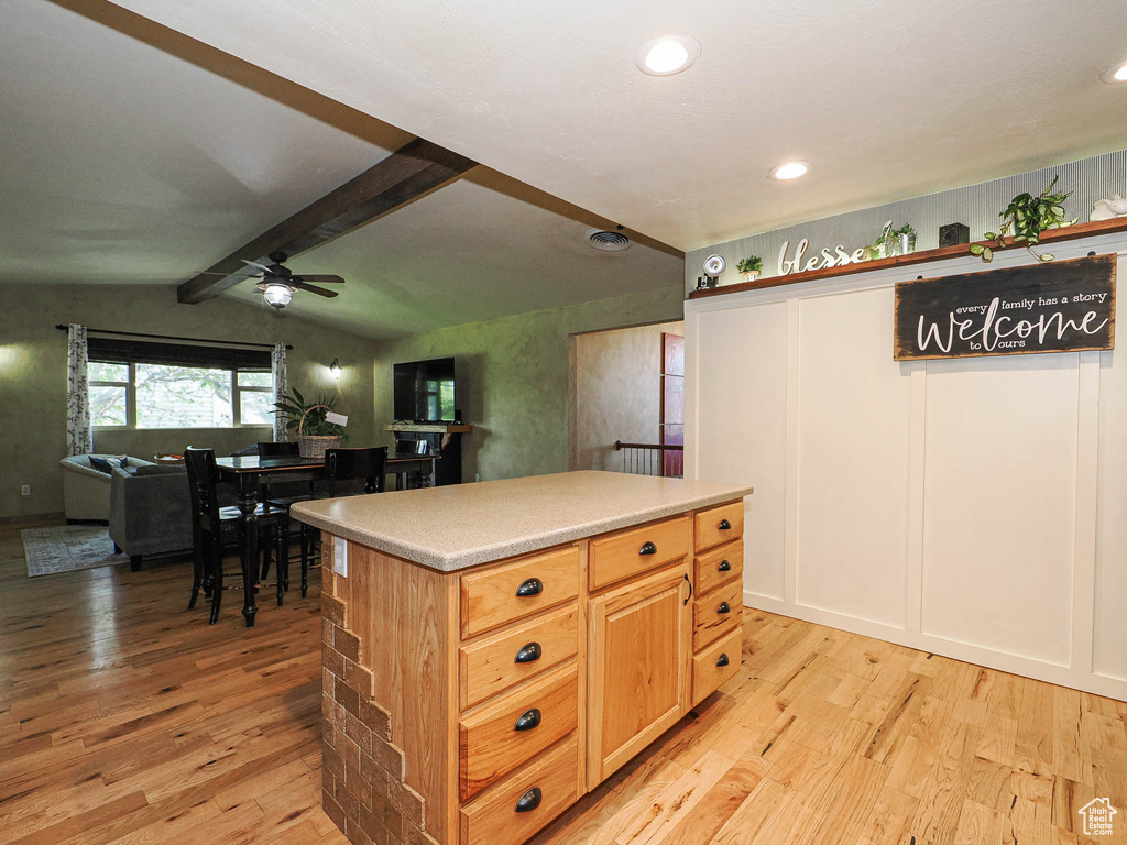 Kitchen featuring light wood finished floors, ceiling fan, light countertops, open floor plan, and recessed lighting