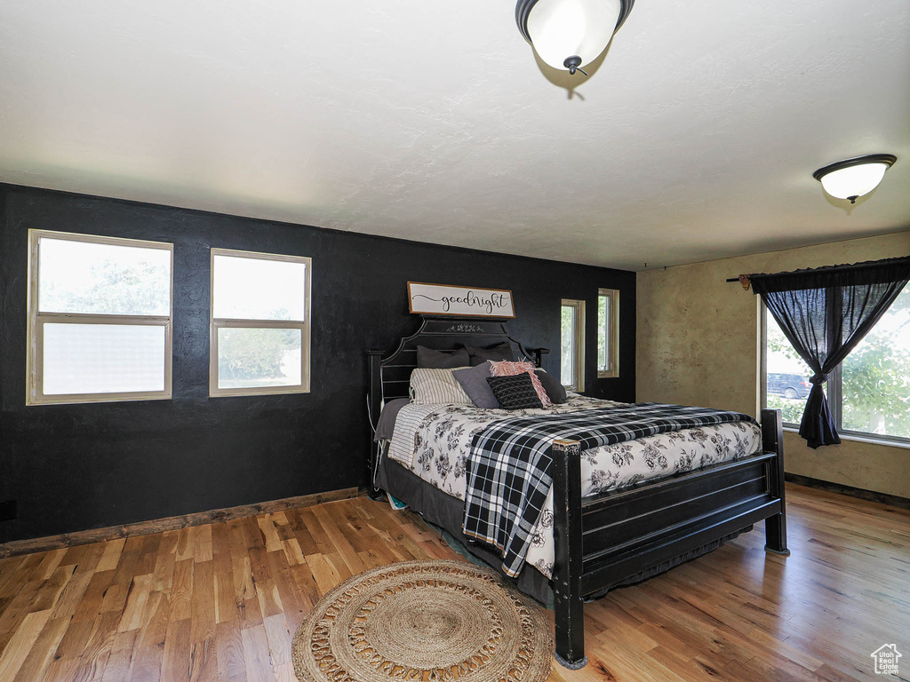 Bedroom with wood finished floors and baseboards