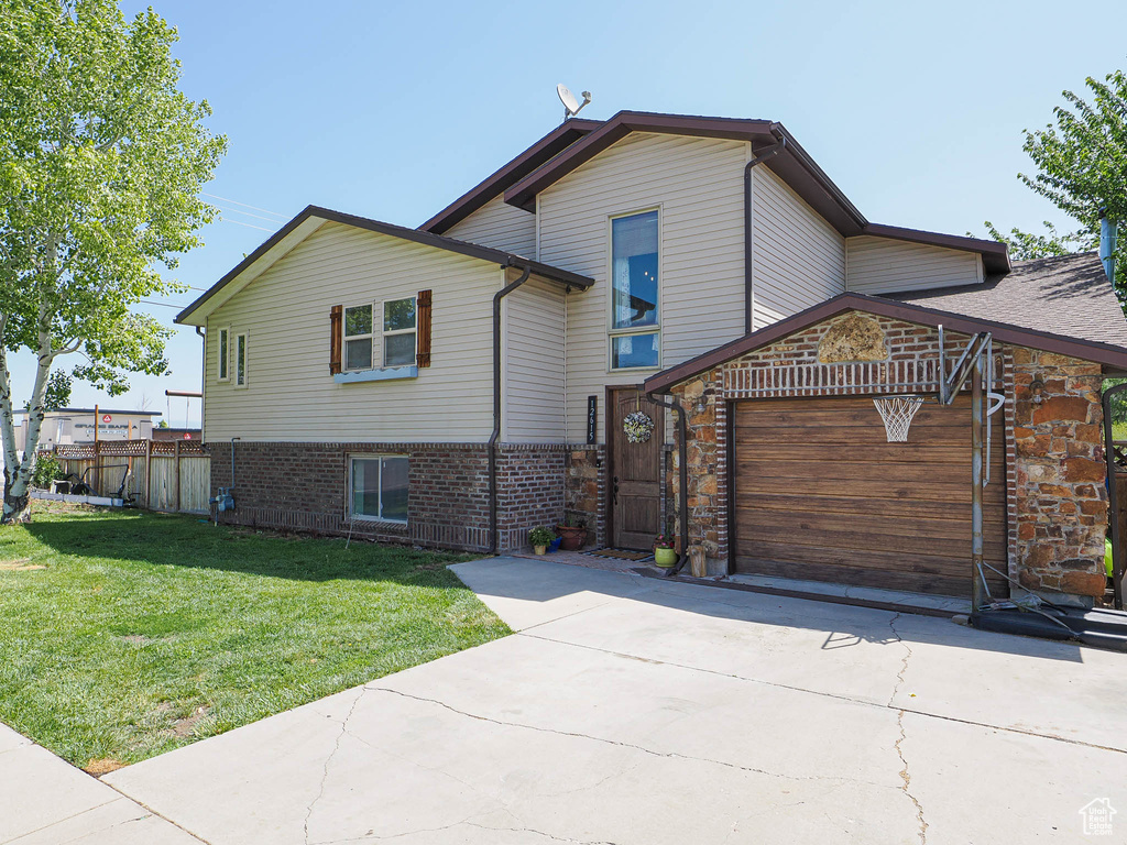 View of front of house with concrete driveway, an attached garage, and brick siding