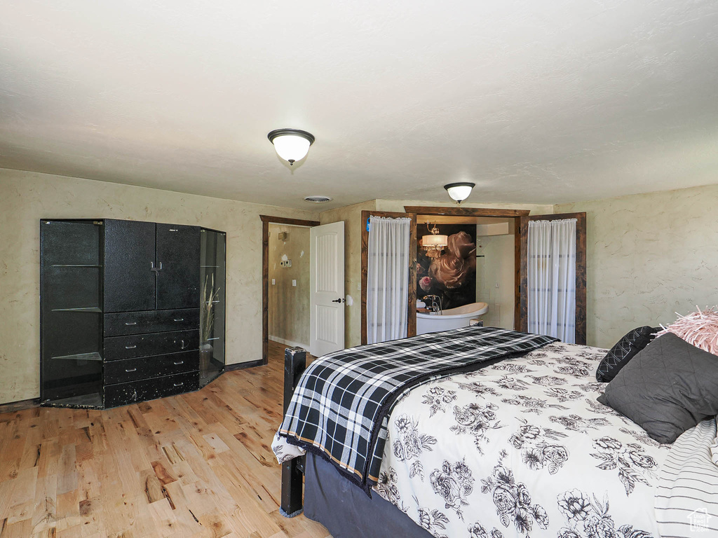 Bedroom featuring light wood finished floors and a textured wall
