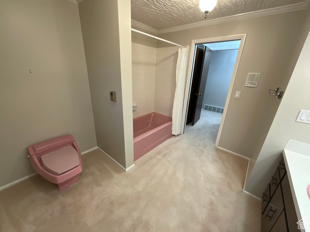 Full bathroom featuring shower / bath combination with curtain, vanity, crown molding, and a textured ceiling