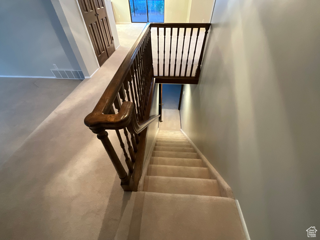 Stairway with baseboards and carpet flooring