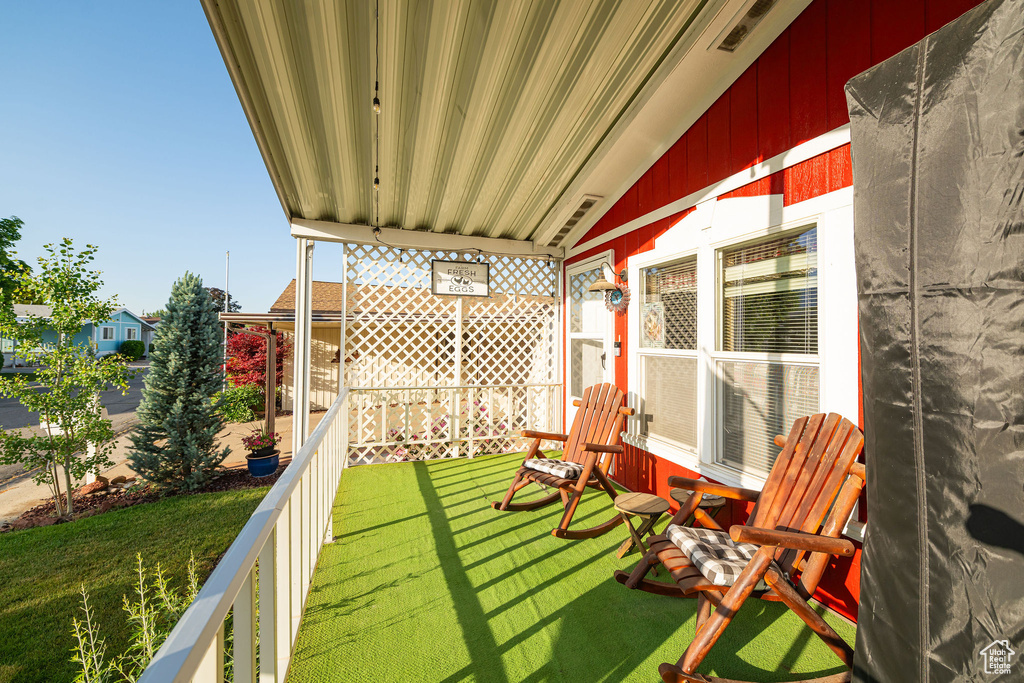 View of grassy yard with a balcony