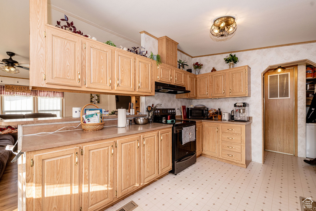 Kitchen featuring electric range, under cabinet range hood, light brown cabinetry, a ceiling fan, and a peninsula