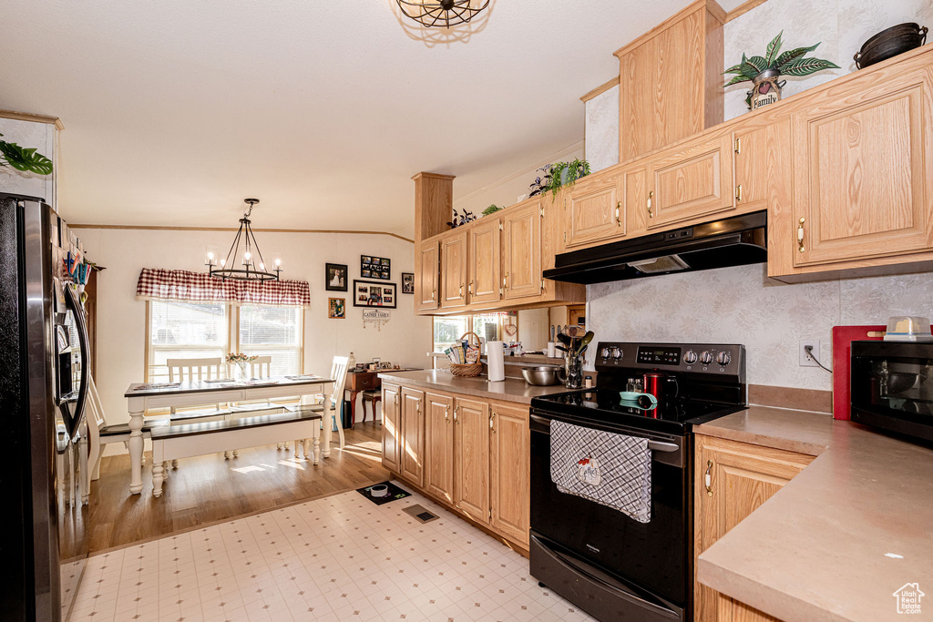 Kitchen with electric range oven, under cabinet range hood, fridge with ice dispenser, light brown cabinetry, and ornamental molding