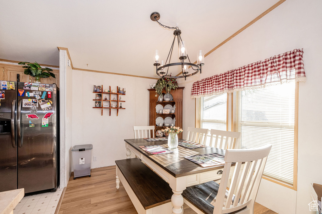 Dining room featuring a chandelier, light wood-style floors, and ornamental molding