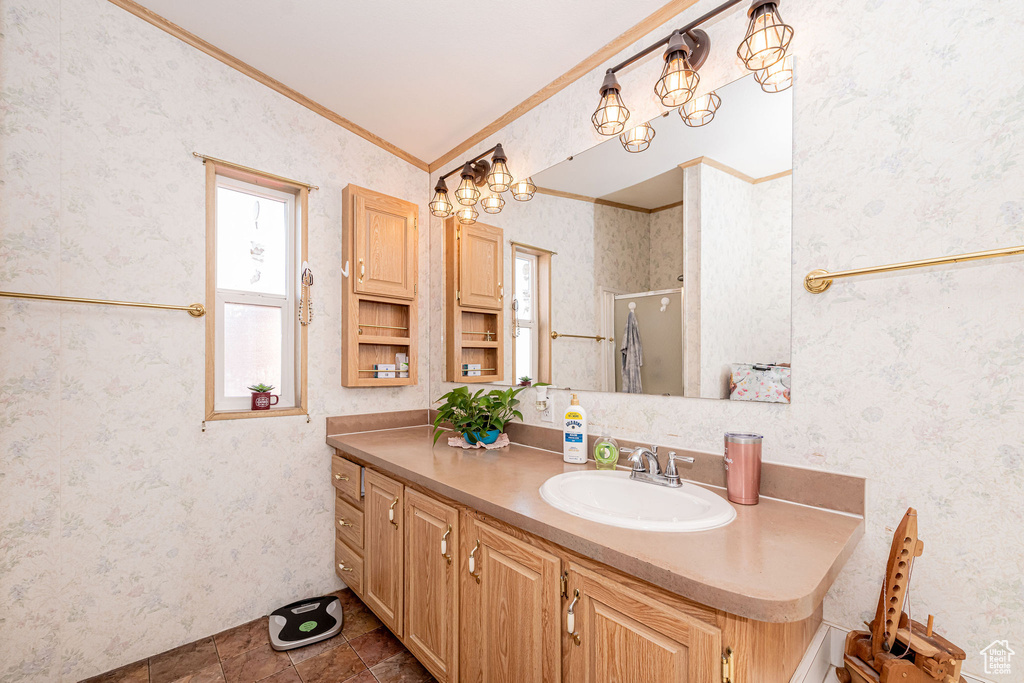 Bathroom with ornamental molding, vanity, a shower with door, lofted ceiling, and wallpapered walls