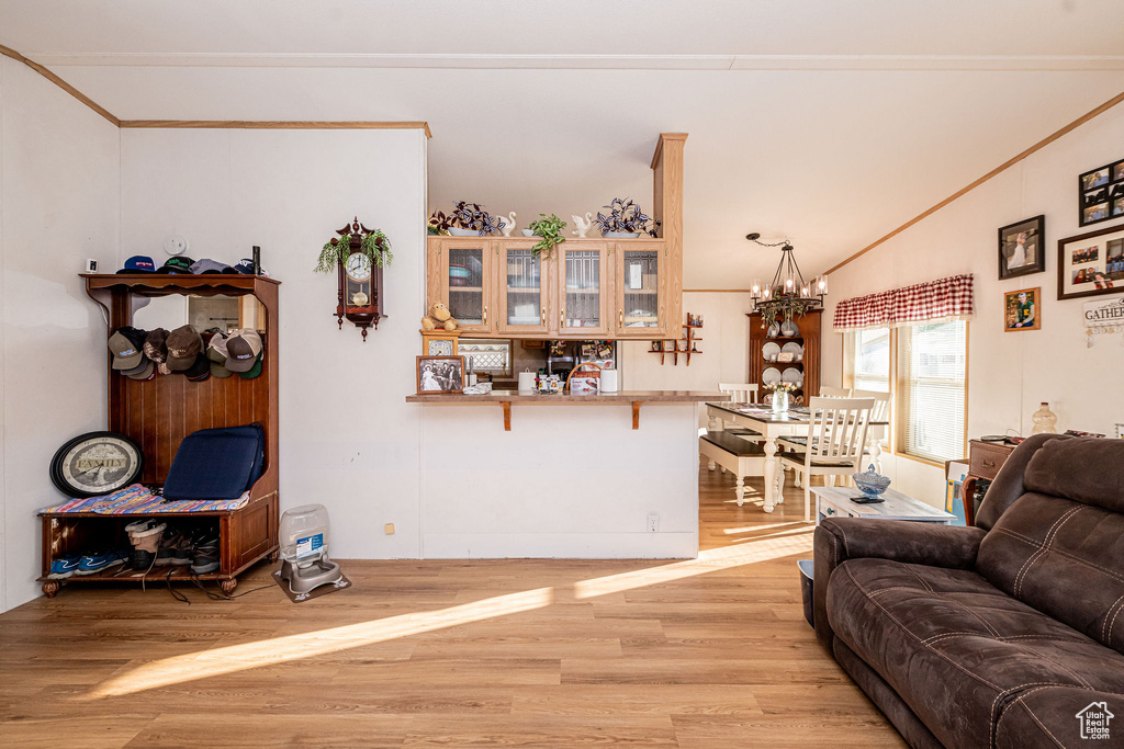 Living area with light wood-type flooring, a chandelier, and lofted ceiling