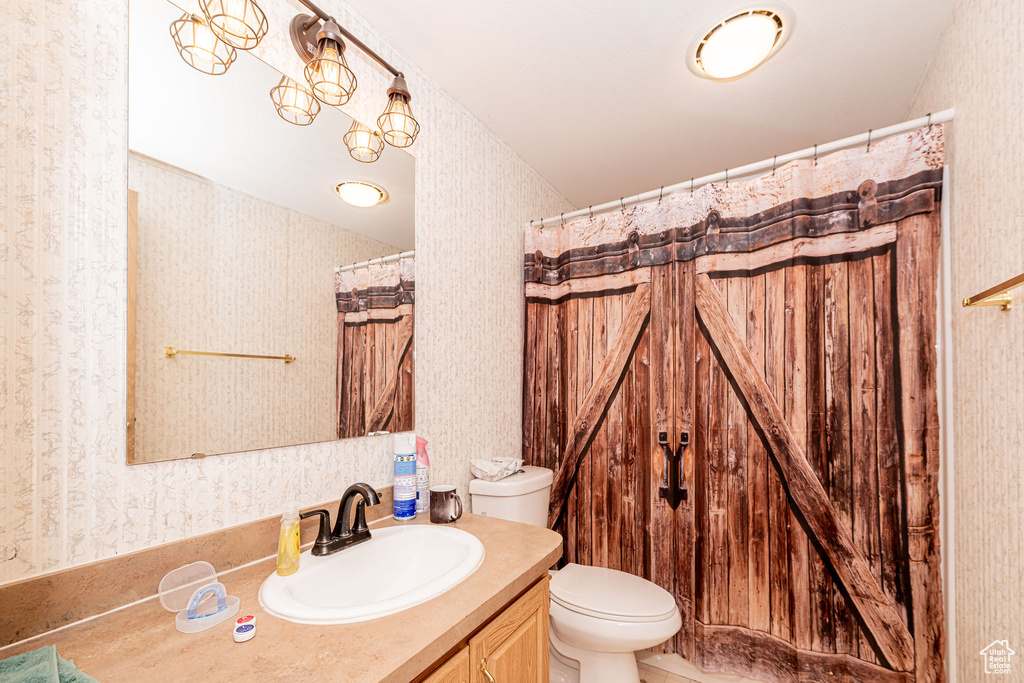 Full bathroom with wallpapered walls and vanity