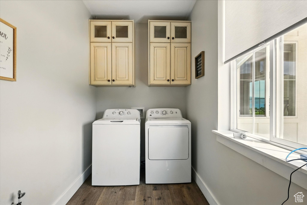 Laundry room with cabinet space, washing machine and dryer, and dark wood-style floors