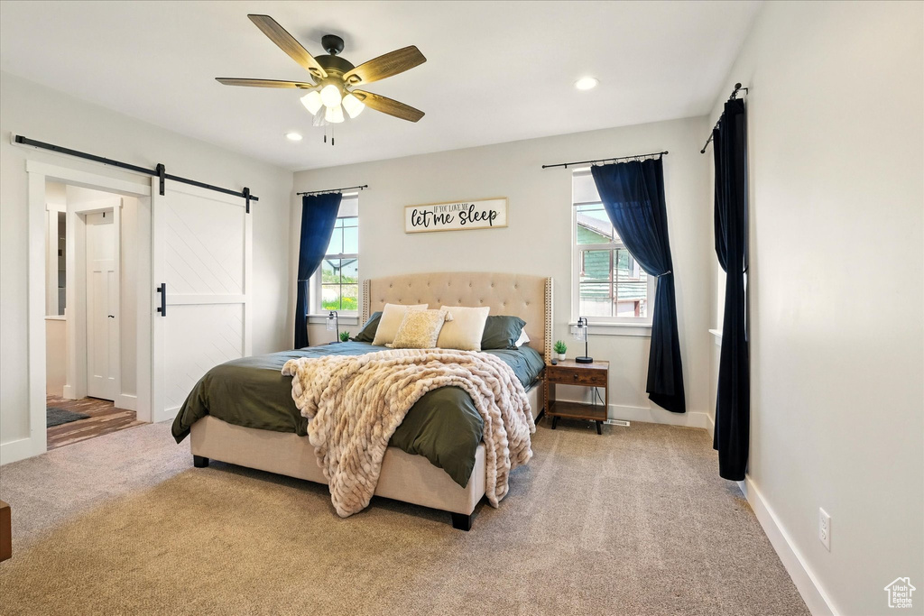 Bedroom with carpet flooring, a barn door, multiple windows, recessed lighting, and a ceiling fan