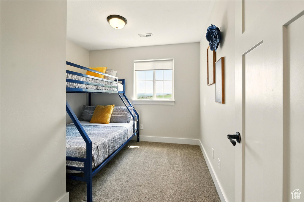 Bedroom featuring carpet and baseboards