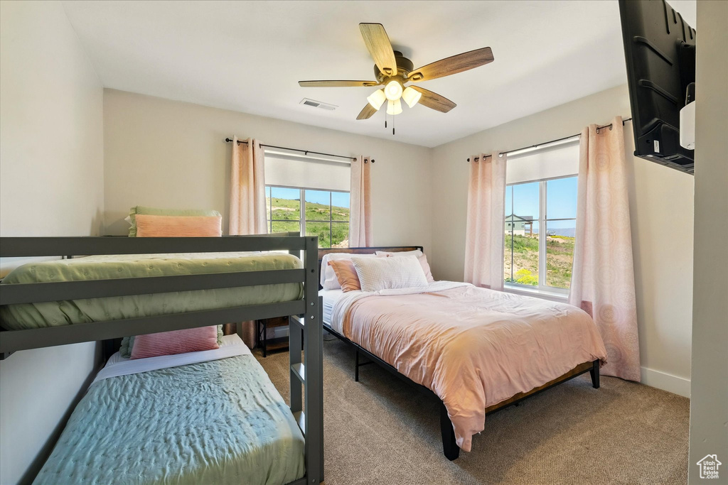 Carpeted bedroom with baseboards and a ceiling fan