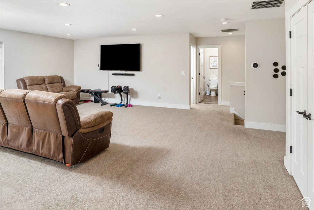 Carpeted living area featuring recessed lighting and baseboards