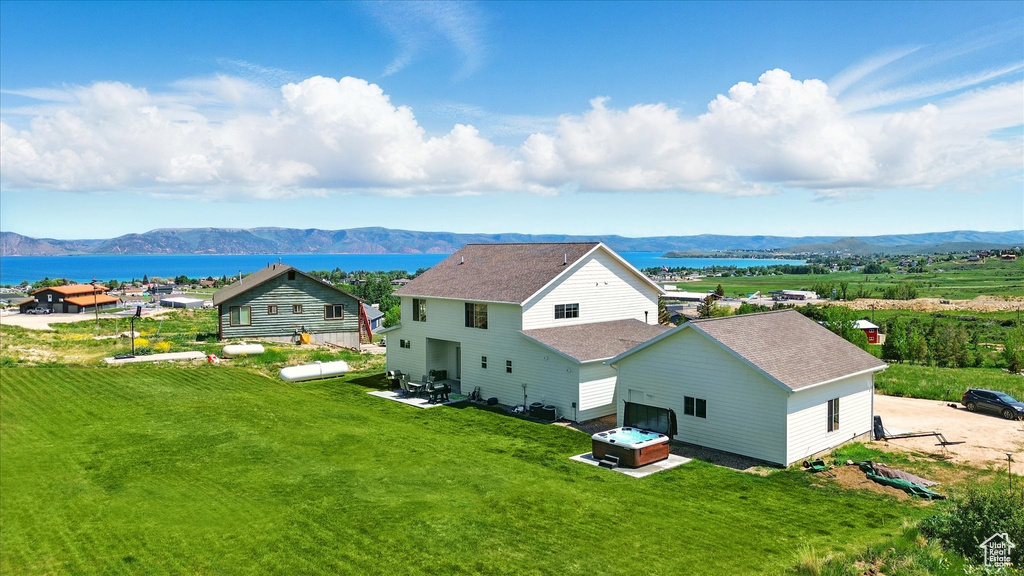 Aerial view of property and surrounding area featuring a water and mountain view