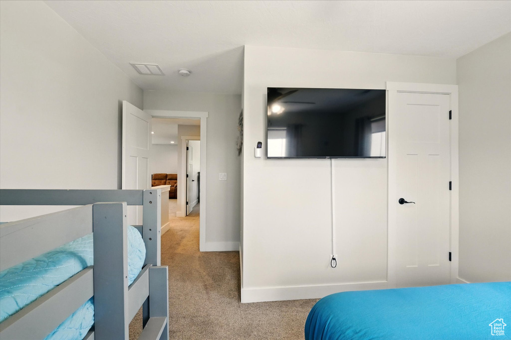 Bedroom featuring carpet and baseboards