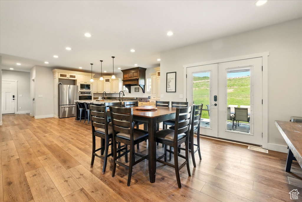 Dining room featuring french doors, recessed lighting, and light wood-style flooring
