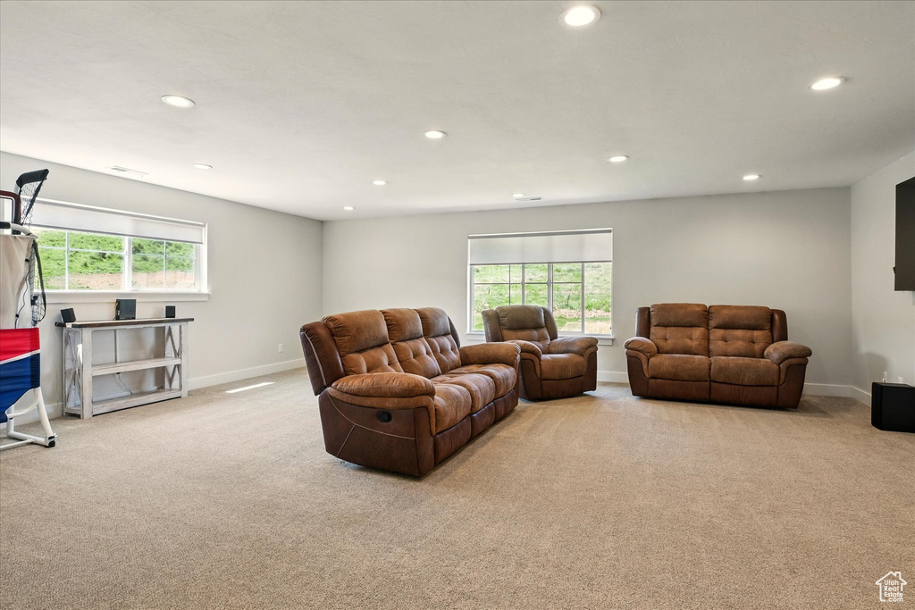 Carpeted living room with recessed lighting and plenty of natural light
