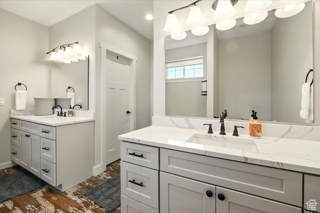 Bathroom with two vanities and wood finished floors