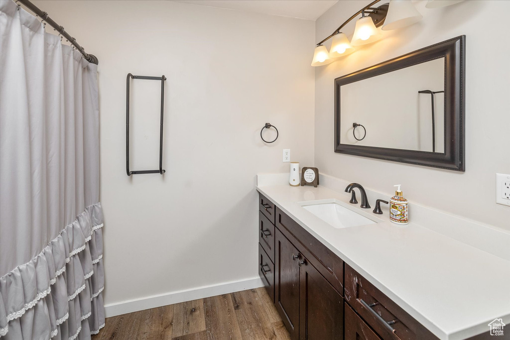 Full bathroom with vanity, wood finished floors, and a shower with curtain