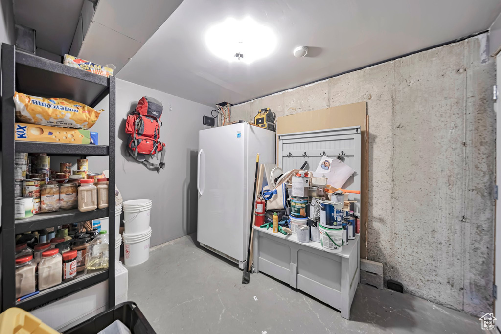Kitchen with freestanding refrigerator and concrete flooring
