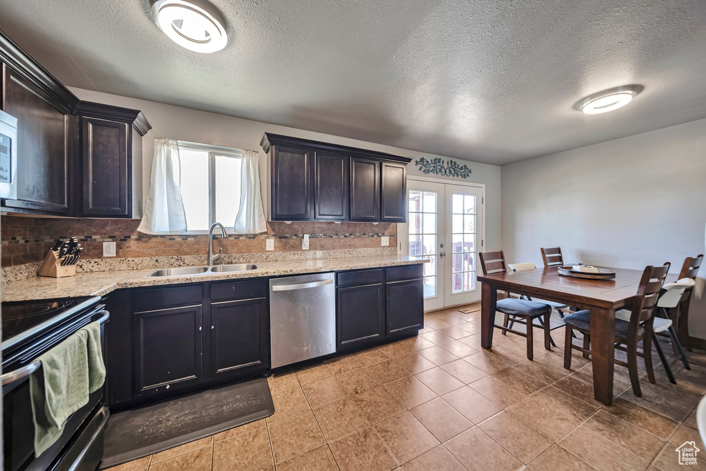 Kitchen with dishwasher, black range with electric stovetop, french doors, decorative backsplash, and a textured ceiling