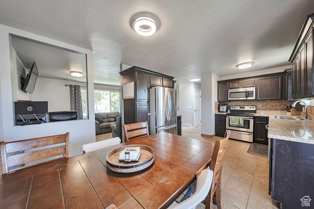 Dining room featuring light tile patterned floors and a textured ceiling