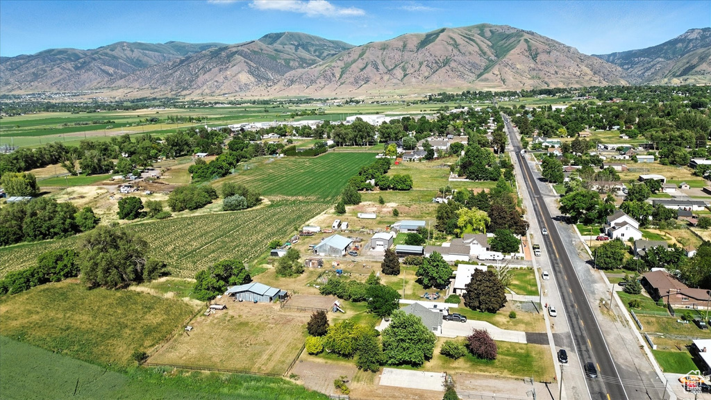 Aerial view of property and surrounding area featuring farmland, mountains, and rural landscape