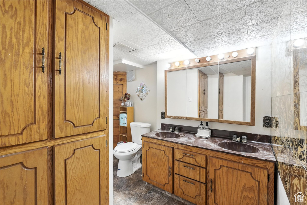 Full bathroom with double vanity and a drop ceiling