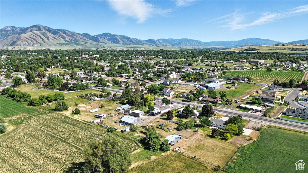 Aerial view of property and surrounding area featuring mountains, rows of crops, and rural landscape