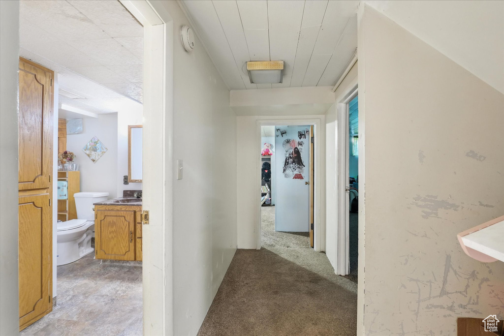Hall with a sink and light carpet