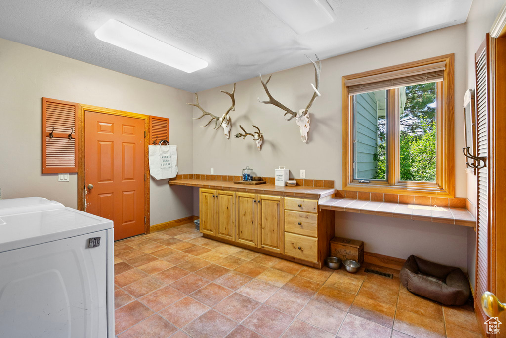 Laundry room with cabinet space, washing machine and dryer, and an office area