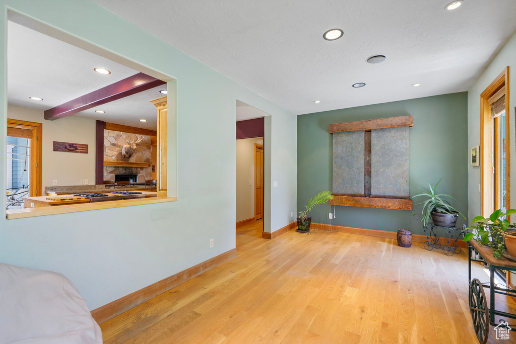 Living area with wood finished floors, recessed lighting, and a stone fireplace