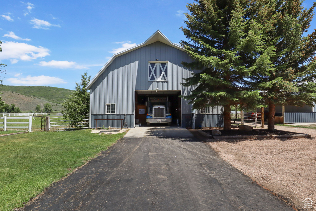 View of front of property featuring a barn, an outdoor structure, and a mountain view
