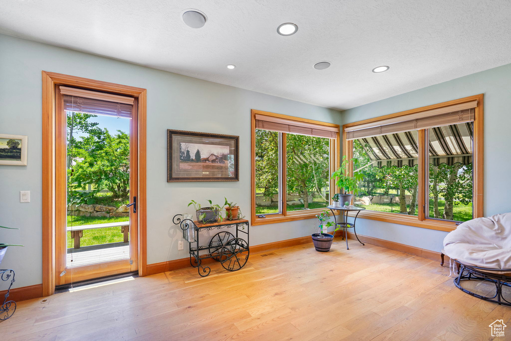 Living area with wood finished floors, plenty of natural light, and recessed lighting