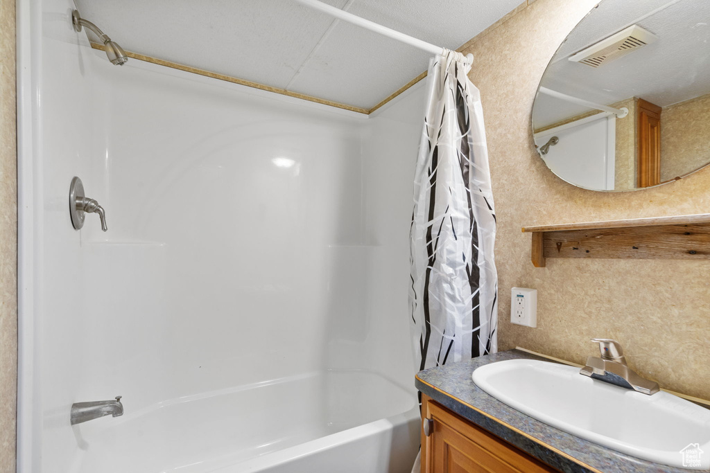 Bathroom featuring shower / bath combo with shower curtain and vanity
