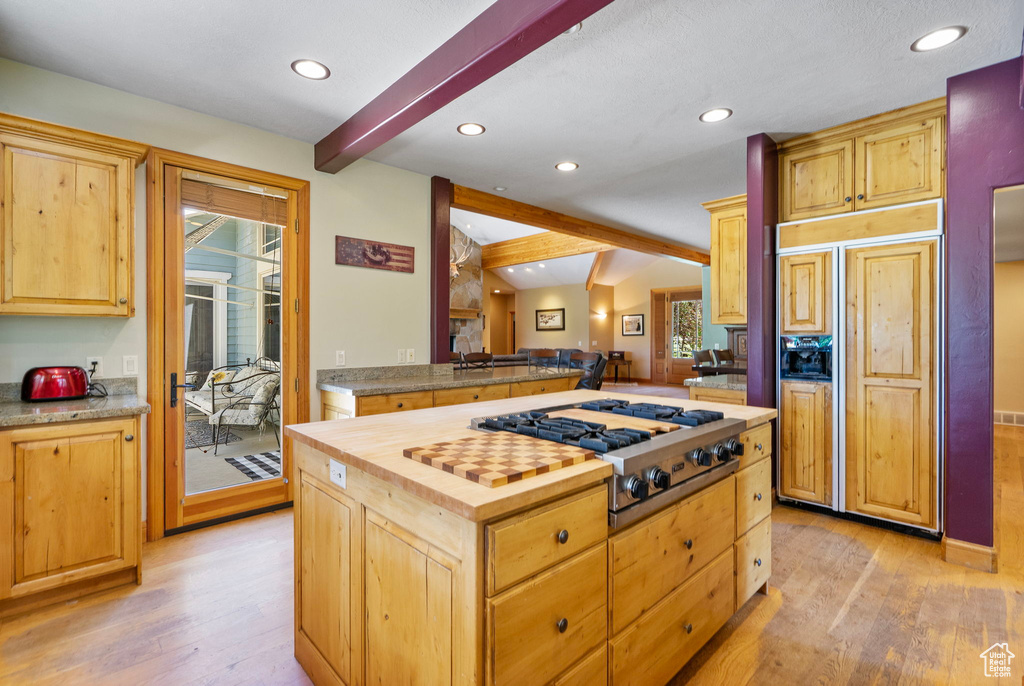 Kitchen featuring stainless steel gas cooktop, paneled fridge, light wood-style flooring, plenty of natural light, and recessed lighting