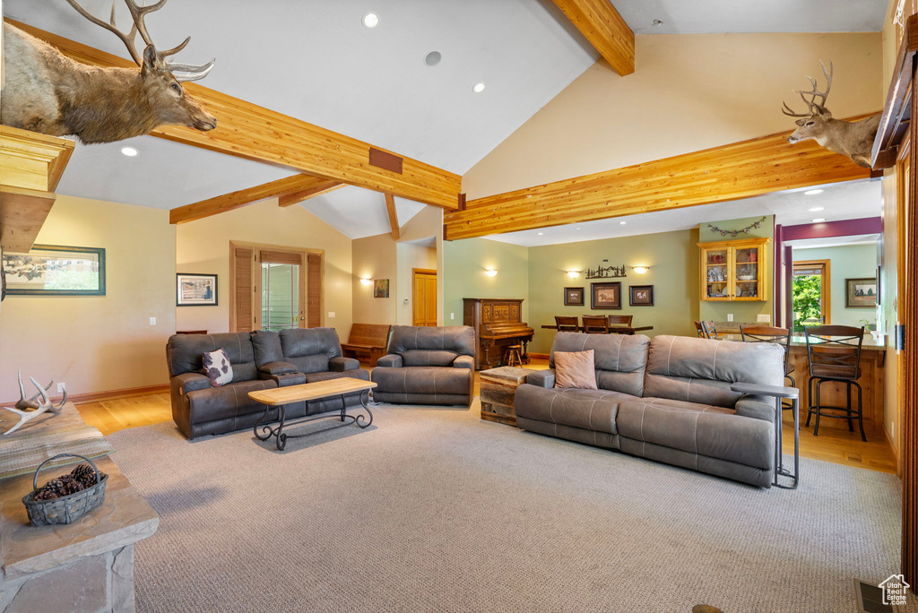 Living room featuring beamed ceiling, recessed lighting, high vaulted ceiling, and wood finished floors