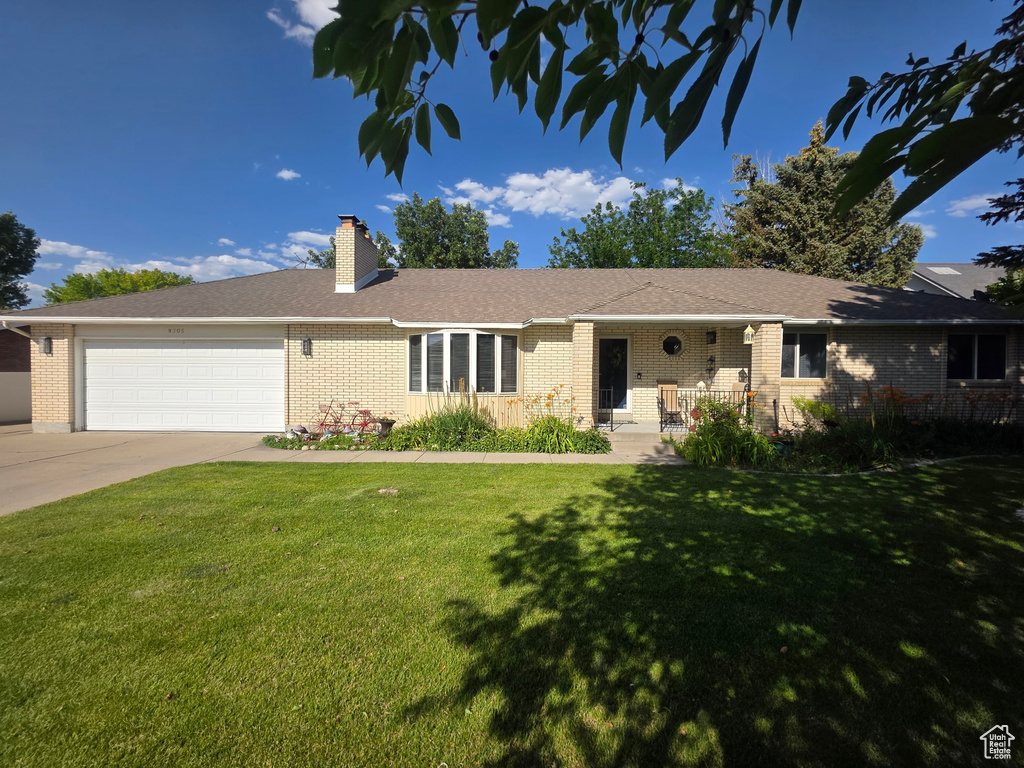 Ranch-style home with brick siding, a front yard, an attached garage, and driveway