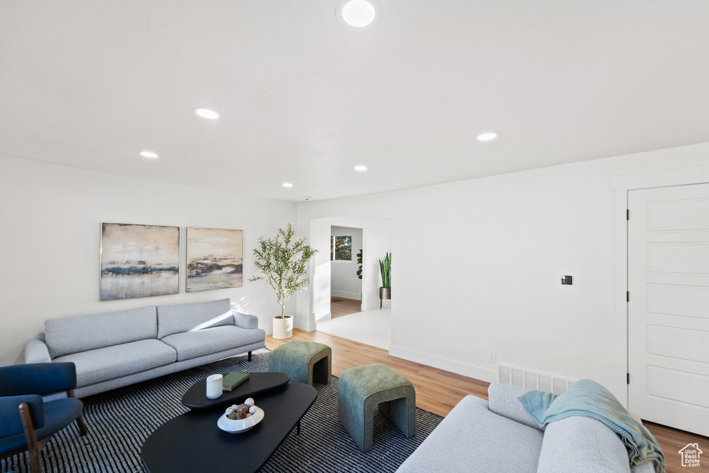 Living room with light wood-type flooring and recessed lighting