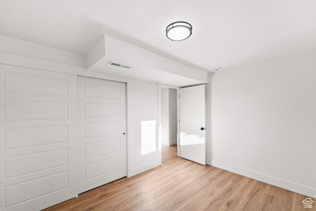 Unfurnished bedroom featuring light wood-type flooring and a closet