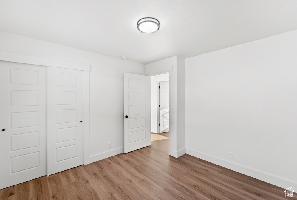 Unfurnished bedroom featuring wood finished floors and a closet