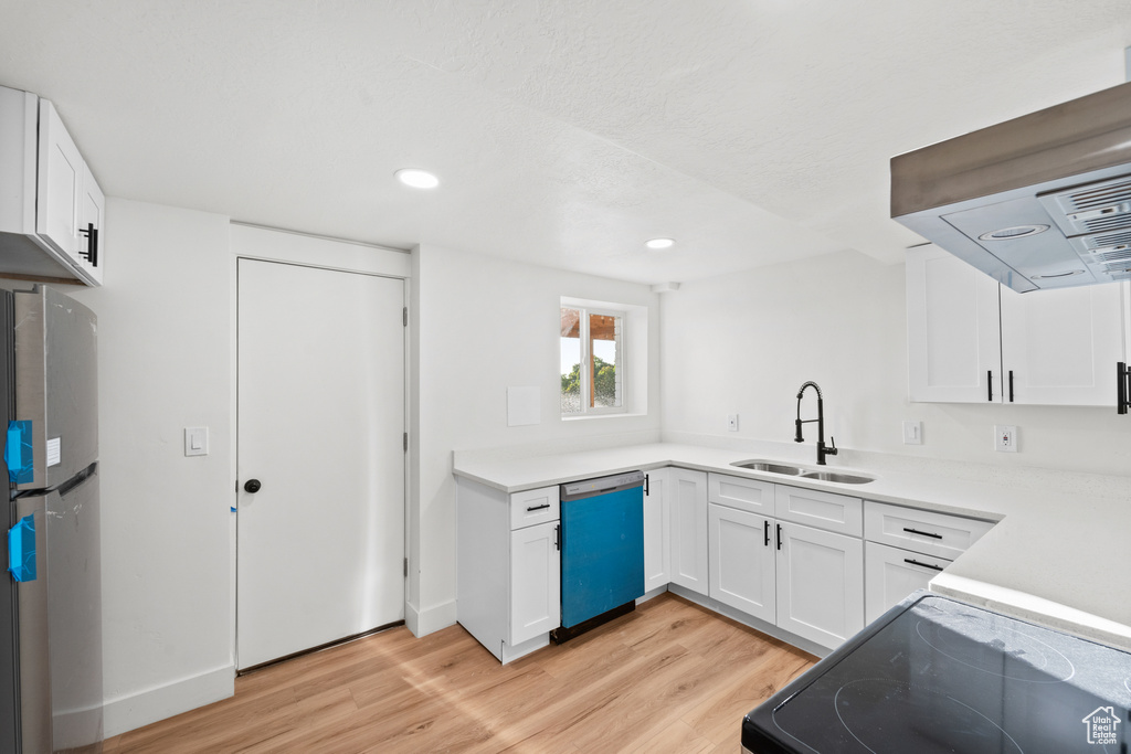 Kitchen featuring dishwashing machine, freestanding refrigerator, light wood-type flooring, white cabinetry, and black electric range