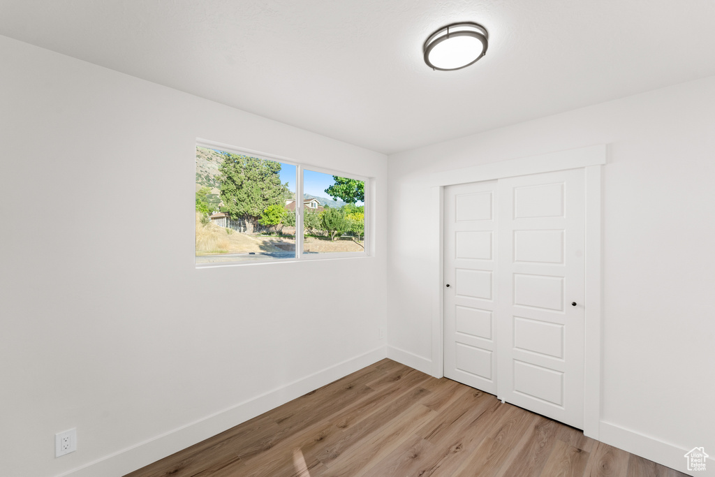 Unfurnished bedroom featuring light wood-style floors and a closet